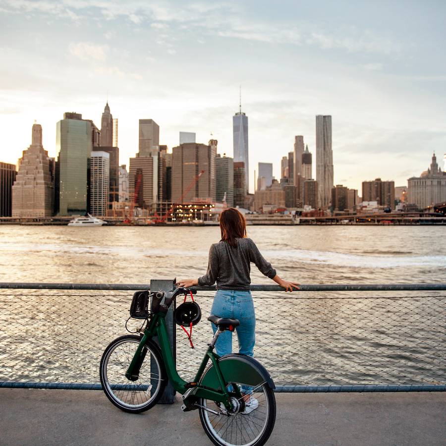 Woman with bicycle overlooking city